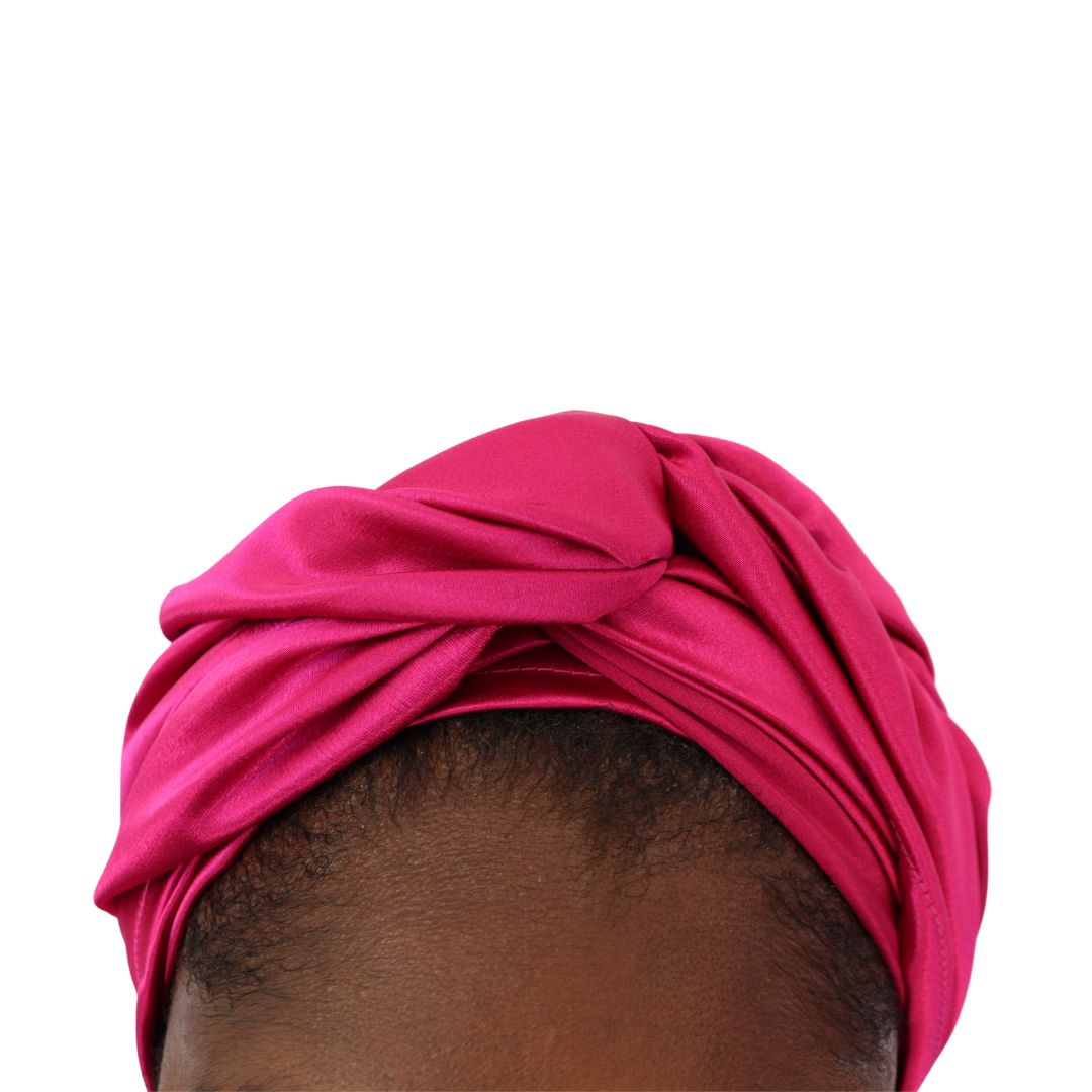 Femme noire portant un foulard de type headwrap en satin rose magenta