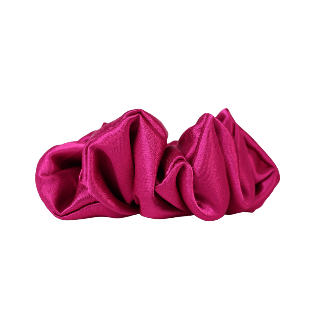 Élastique de type chouchou en satin rose magenta de profil sur fond blanc