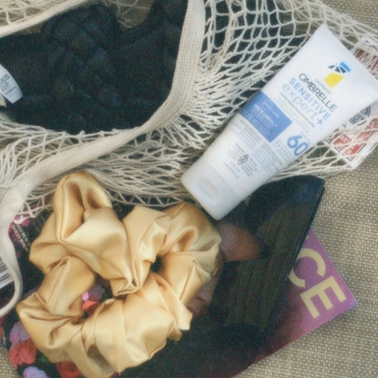 Sac de plage avec une paire de sandale et de la crème solaire